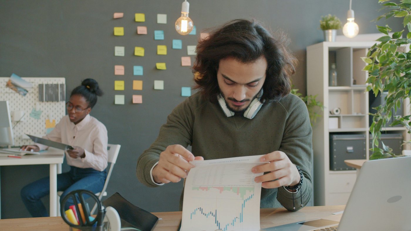 A man reviewing charts at a modern office desk